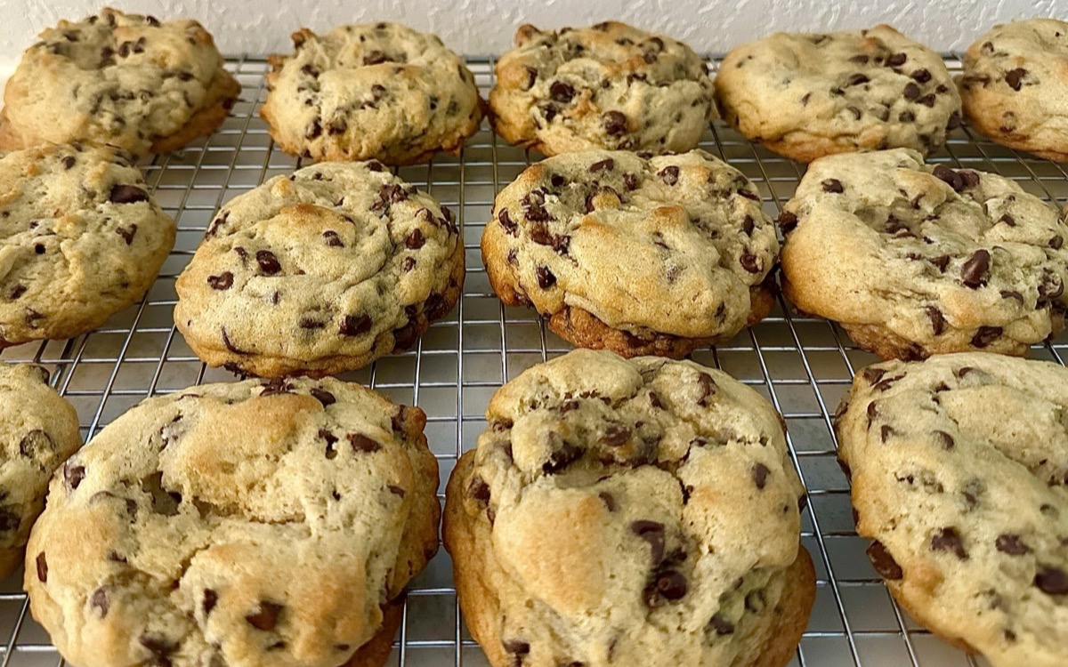 A rack of golden sourdough chocolate chip cookies cooling