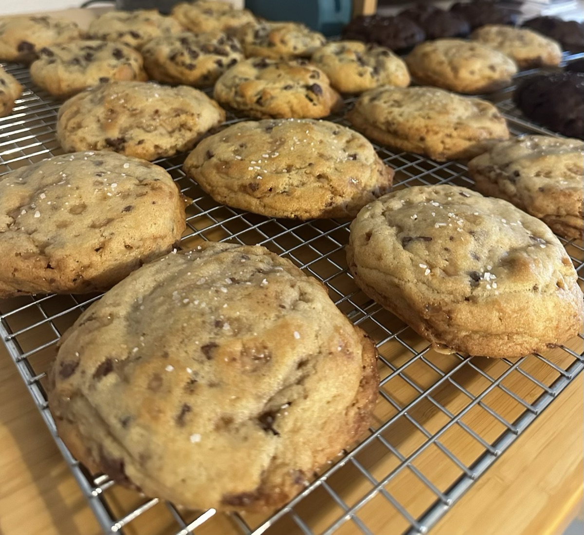 A close-up of golden sourdough cookies cooling on a wire rack